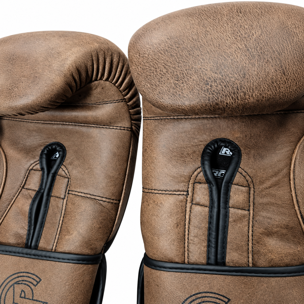 Guantes de boxeo vintage RG Jack Broughton: detalle del cuero y las costuras sobre fondo blanco