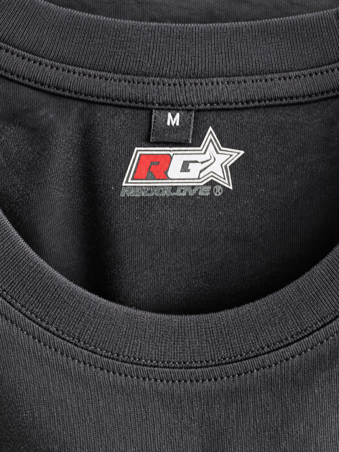 Detalle del cuello interior de camiseta RG Warrior Lifestyle con logotipo RG y talla M